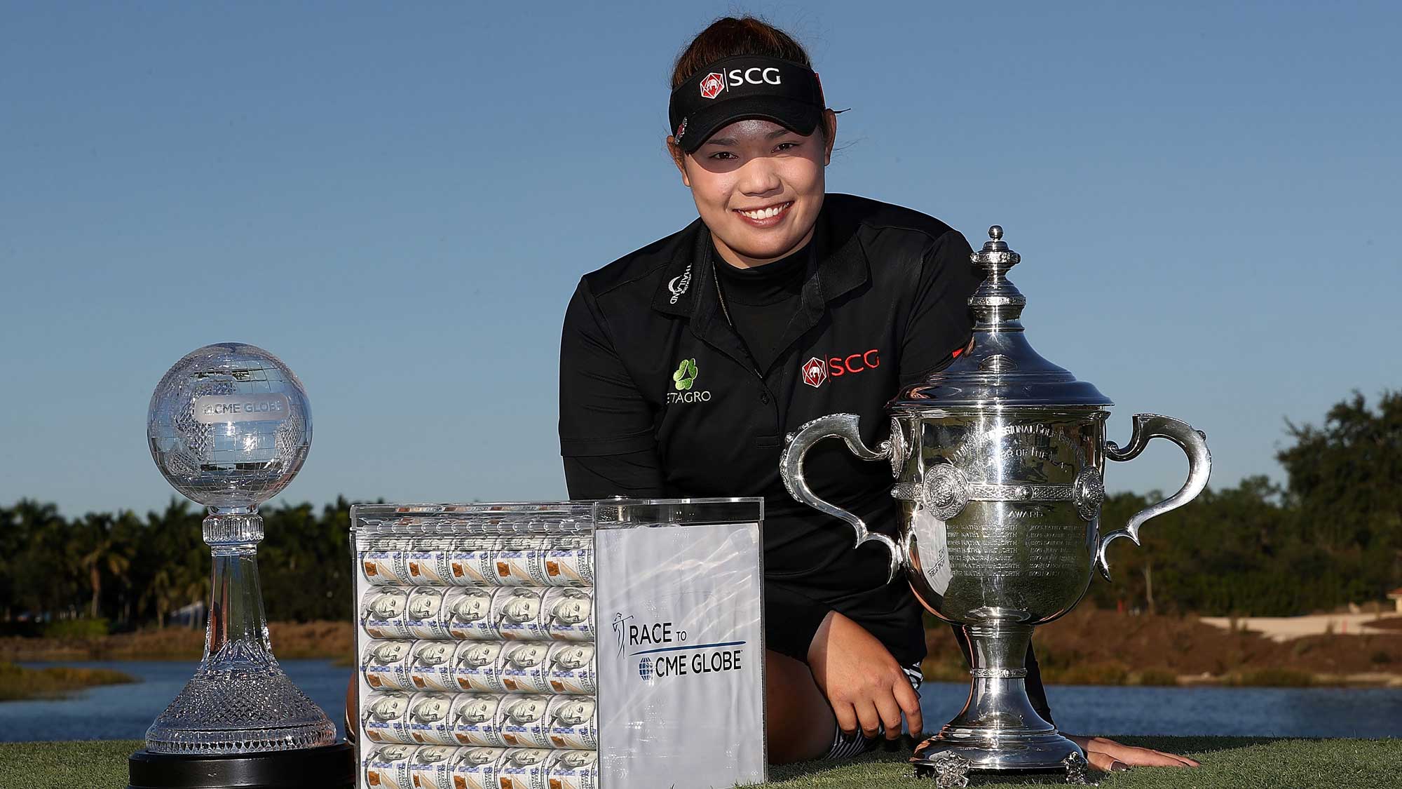 Ariya Jutanugarn of Thailand poses with the Rolex Player of the Year trophy, the CME Race for the Globe trophy and a box of one million dollars in cash during the final round of the CME Group Tour Championship at Tiburon Golf Club